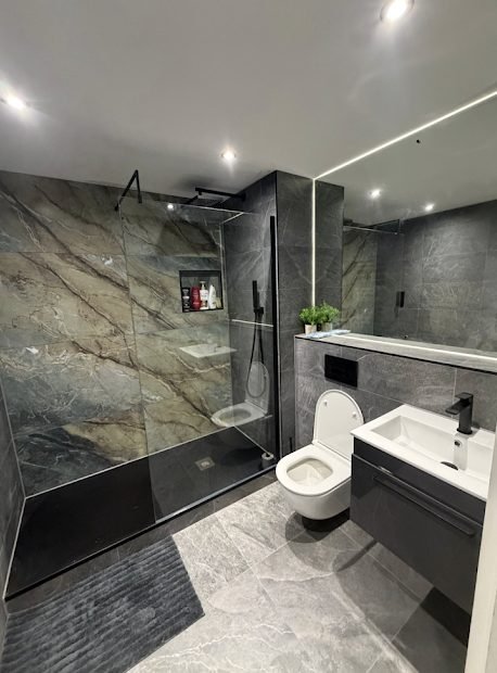 Dark stone effect wet room with level access shower and wall hung WC